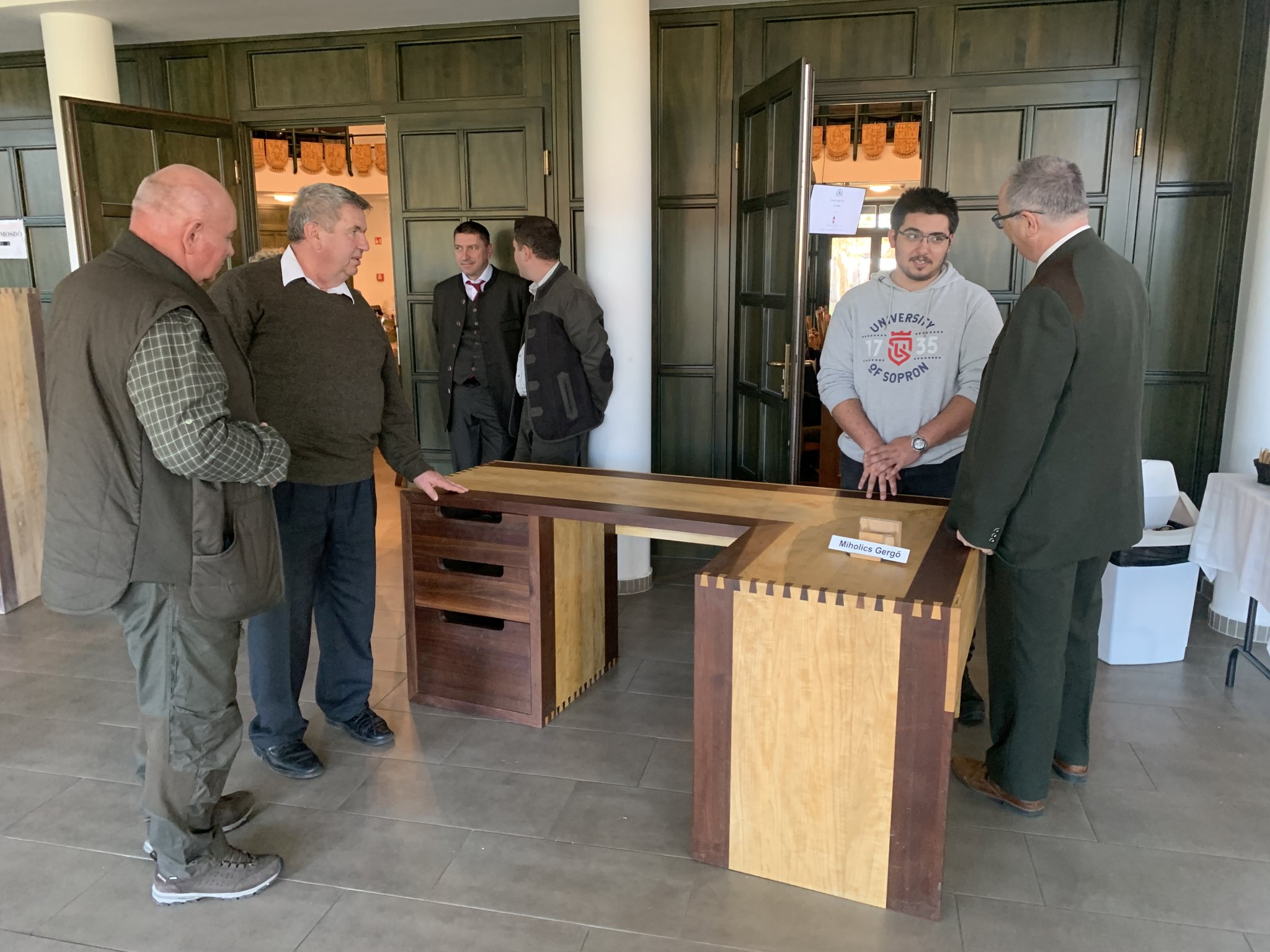 1. kép: Miholics Gergő vizsgaremeke (Soproni SZC Handler Nándor Technikum – szakmunkás képesítés). A világos színű fa alkatrészek nyugati ostorfa (Celtis occidentalis), míg a sötét alkatrészek fekete dió (Juglans nigra) fájából készültek. Az ostorfa kemény, szép rajzolatú fájából készült igényes bútorokat nagy érdeklődés övezte.